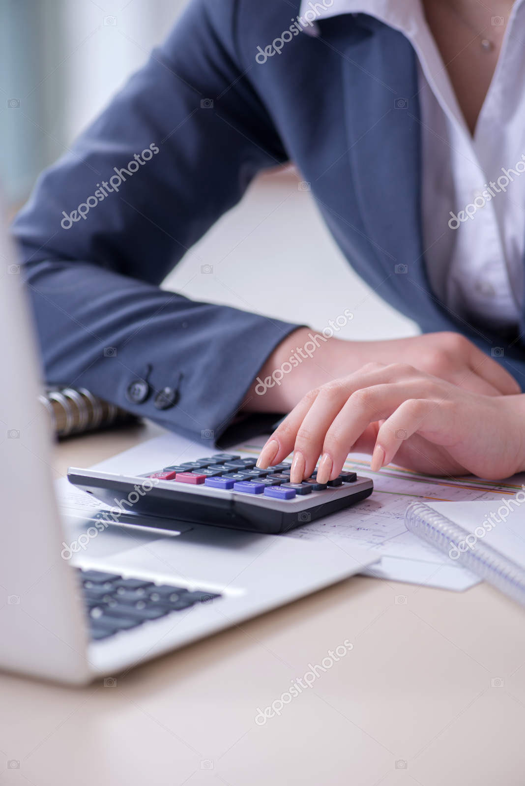 Female finance professional working on keyboard with reports